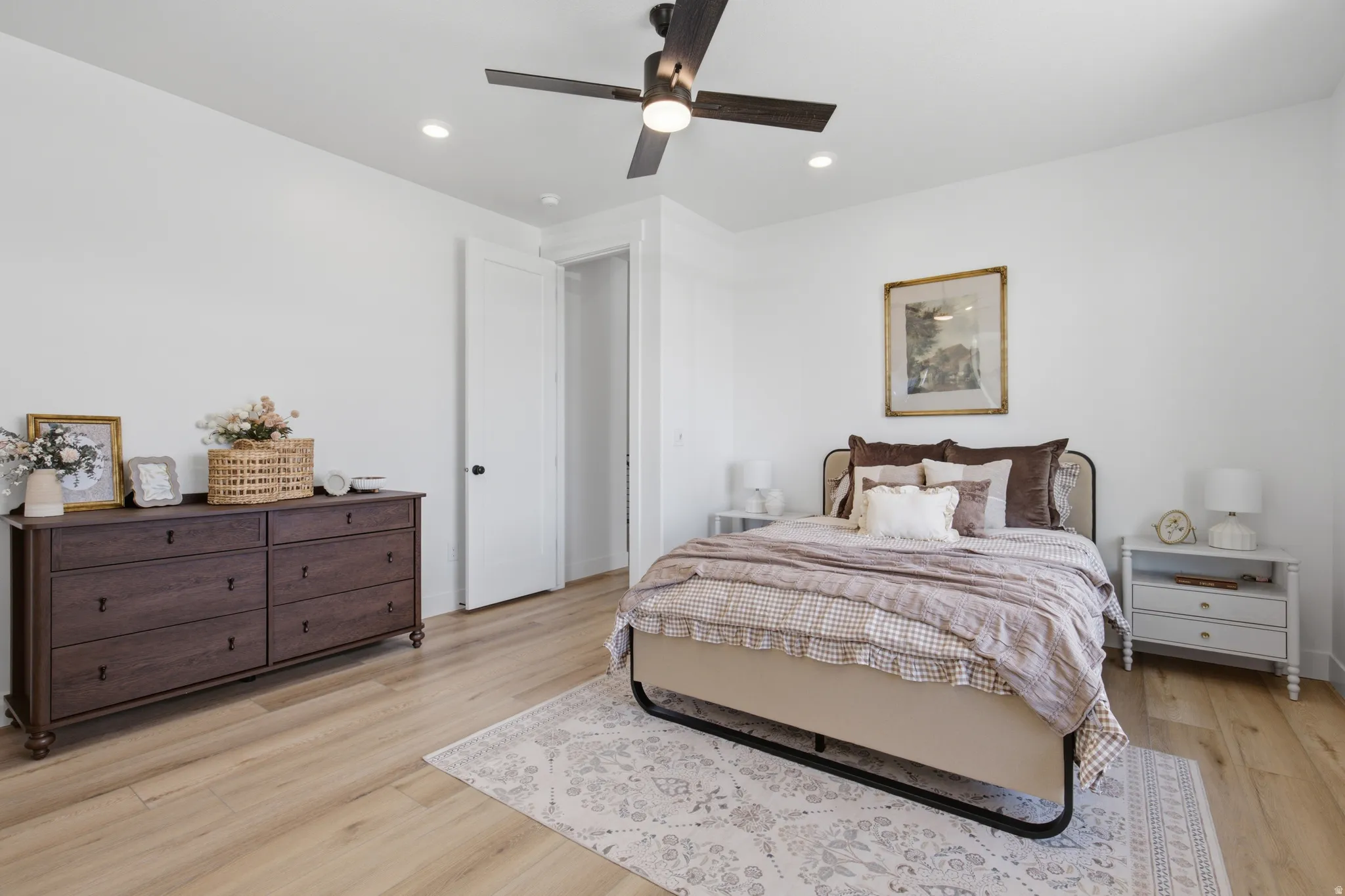 Light wood-finish flooring, recessed lighting, and a ceiling fan with integrated lighting
