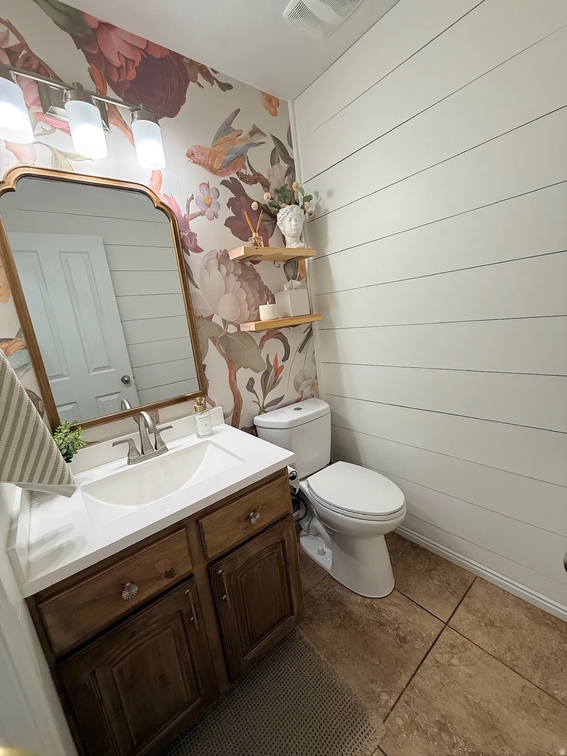 Vanity with wood-finish cabinetry, white countertop, and integrated sink