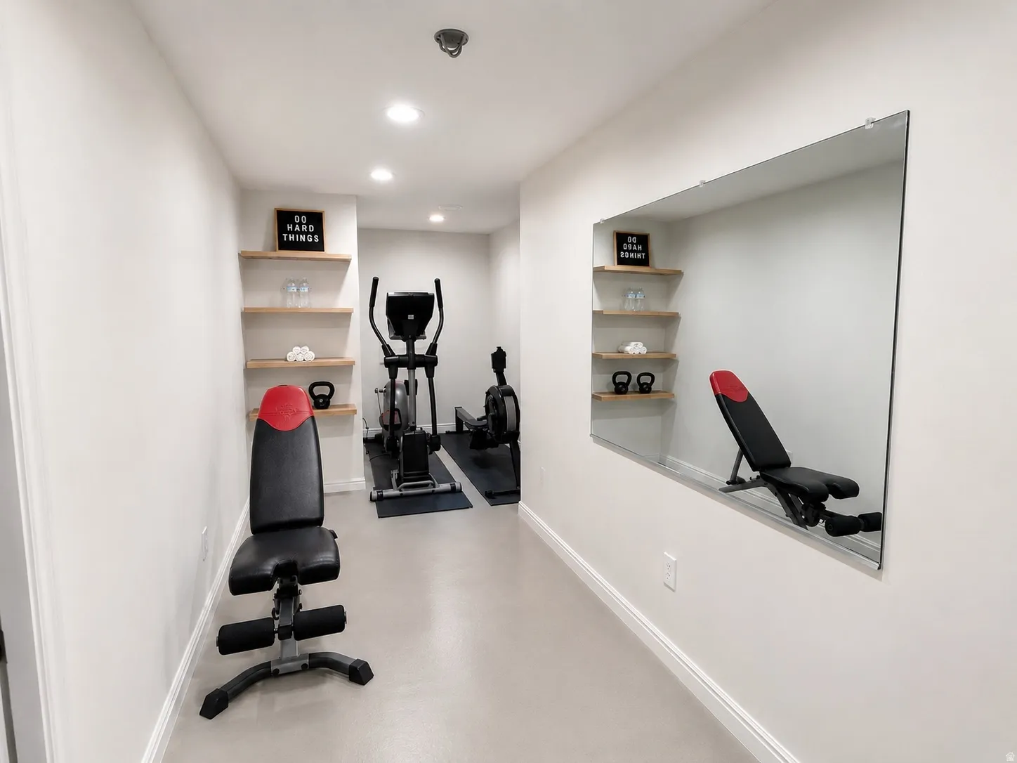 Recessed lighting illuminates this dedicated fitness space with light gray flooring