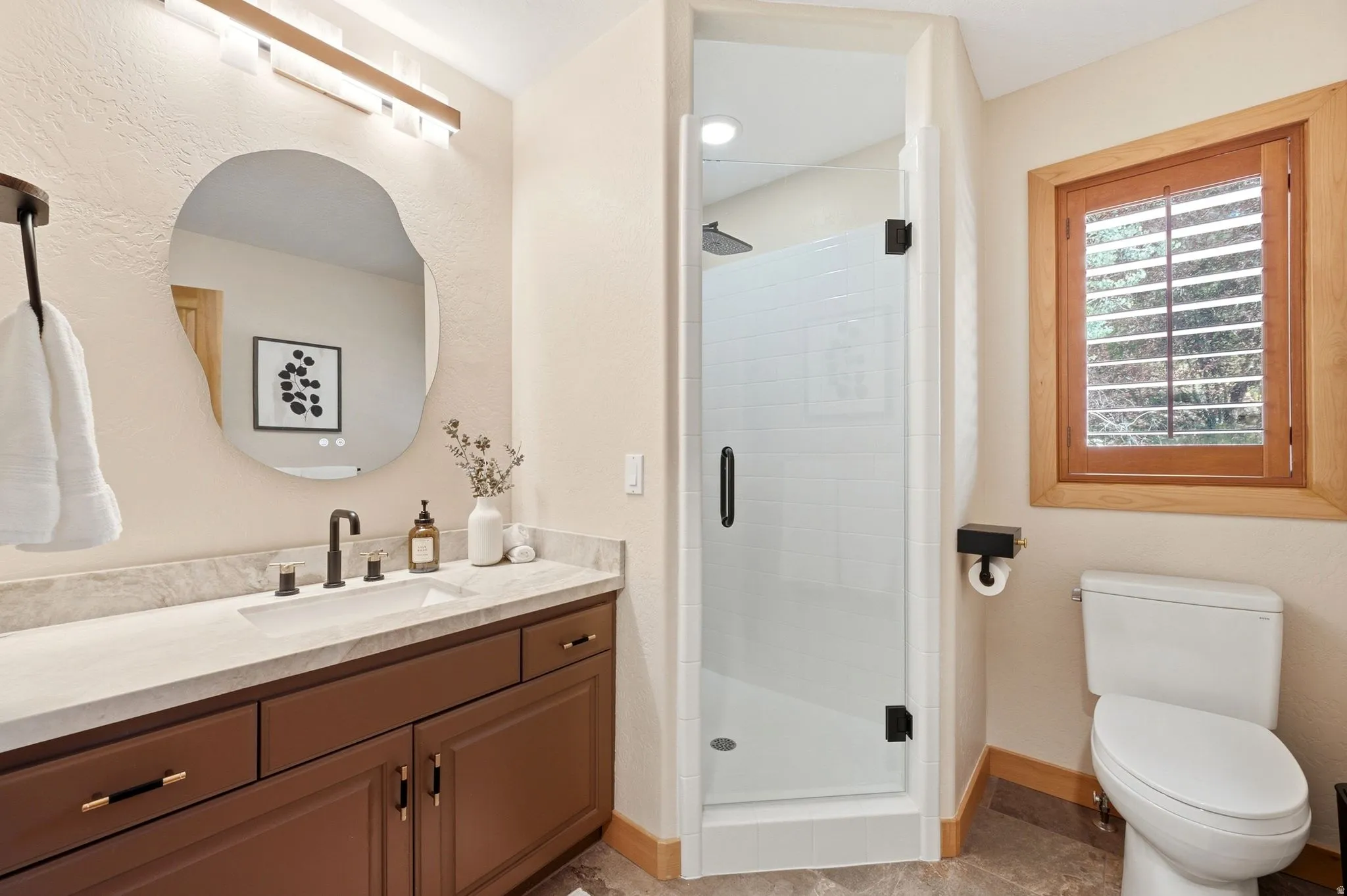 The first-level three-quarter bathroom has been fully updated and has heated floors and Taj Mahal quartzite countertops.