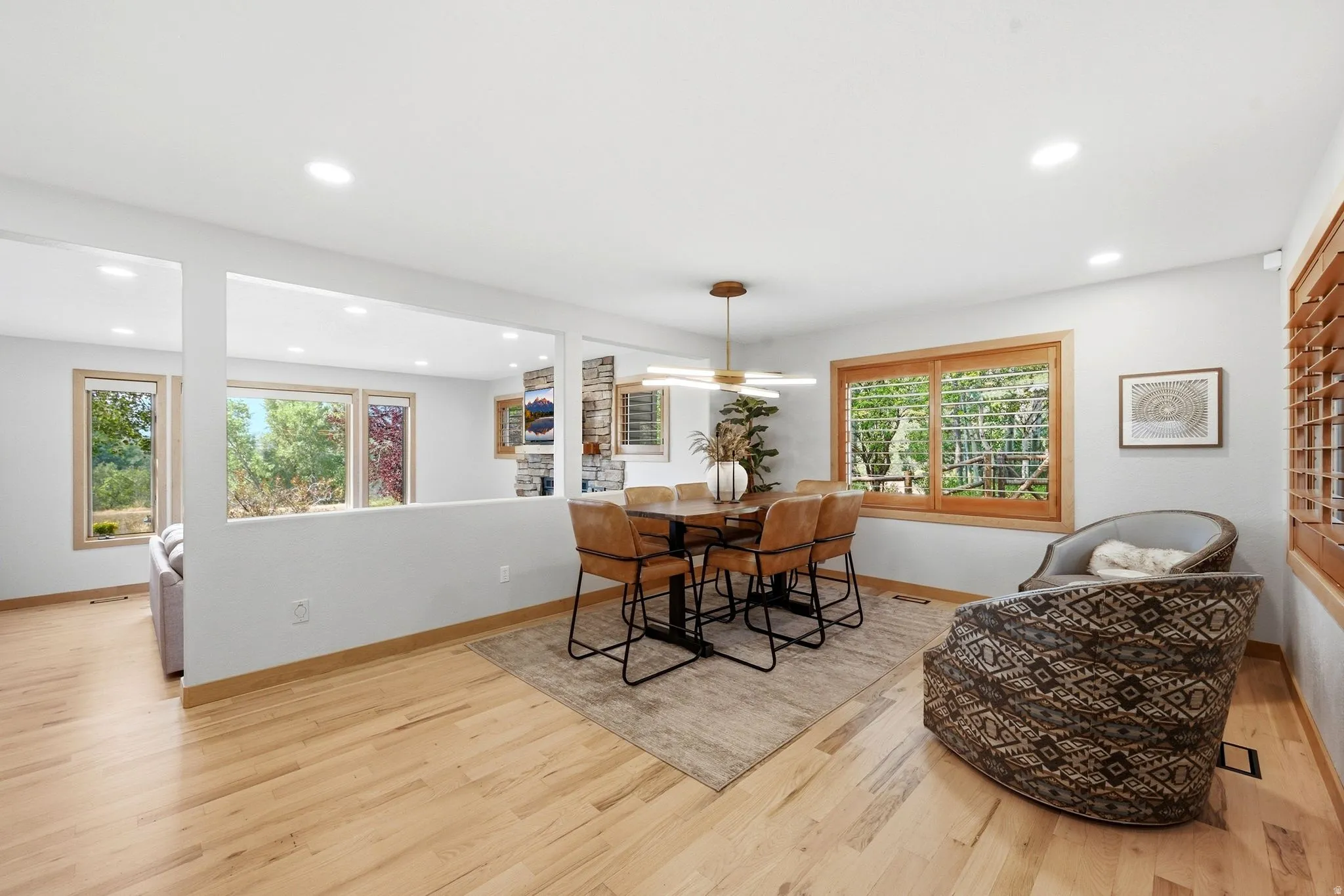 Open concept kitchen, dining, and living area.  Refinished wood flooring throughout, updated lighting, wood-framed windows with wooden shutters, natural light and views.