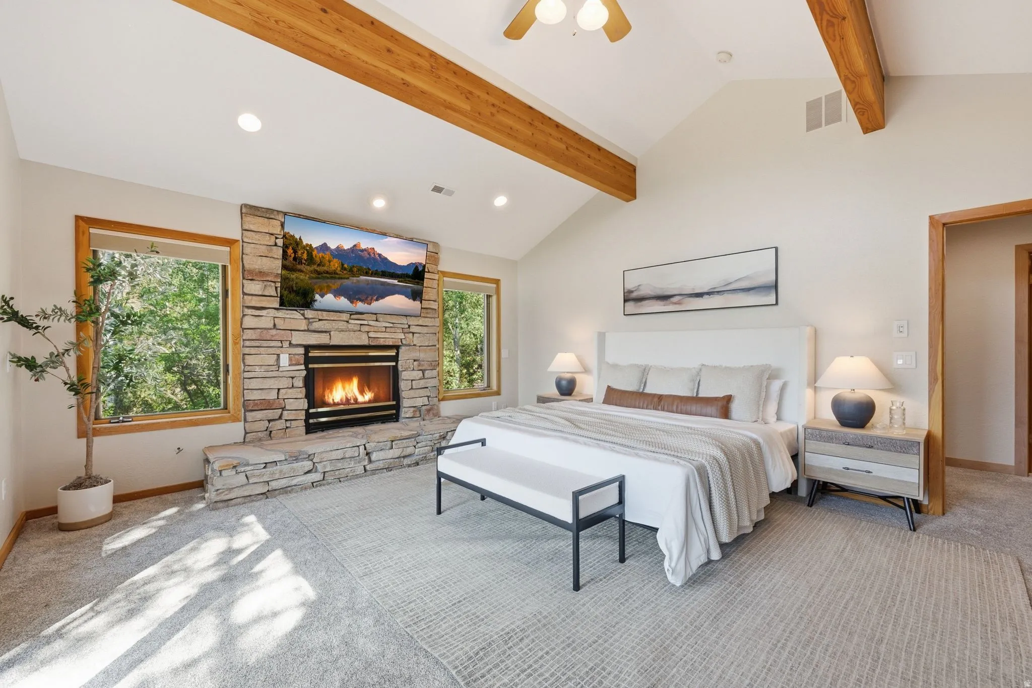 Primary bedroom with vaulted ceilings, fireplace, a private deck, incredible views of the mountains and ski resorts, an en-suite bathroom with a separate jetted tub and shower, heated floors and a walk-in closet.