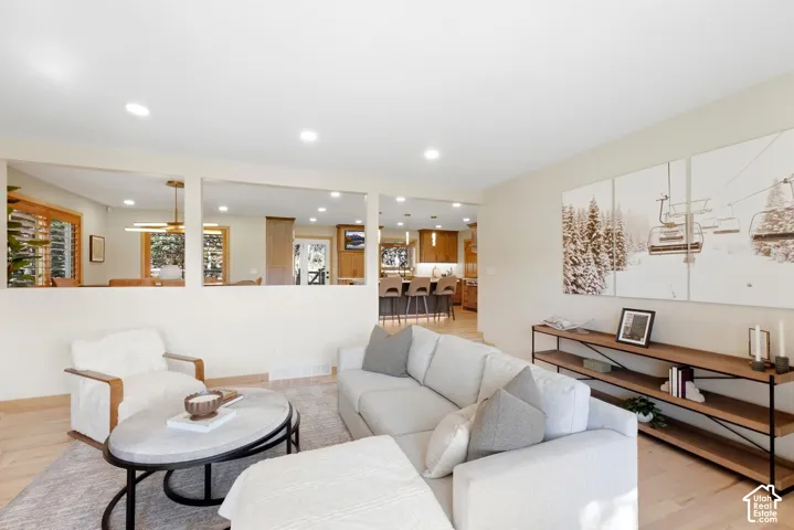Open-concept living area with recessed lighting, wood-finish flooring, and a half-wall partition