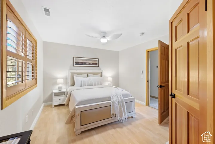 Hardwood-style flooring, wood plantation shutters, ceiling fan, and solid wood doors