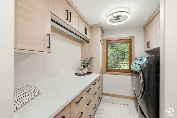 Updated laundry room with heated flooring featuring ample storage wood-Valor Gold Lava quratz countertops new washer and dryer units that stay with the home, and it even has its a built in broom closet.