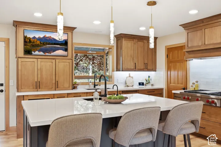 Updated kitchen (2024) featuring Ethereal Glow quartz countertops, updated lighting, high-end cabinetry, under-mount sink with a matte black faucet, and a Wolf range.