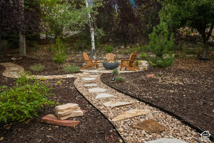 Stone paver pathway leading to a stone fire pit area in the back/side yard.  Imagine getting out the gravity chairs and taking in the stars or sunsets.