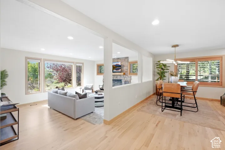 Spacious living area featuring light wood-finish flooring, recessed lighting, and large windows