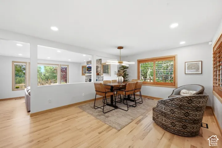 Open concept kitchen, dining, and living area.  Refinished wood flooring throughout, updated lighting, wood-framed windows with wooden shutters, natural light and views.