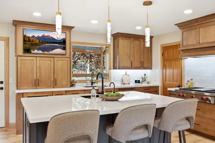 Updated kitchen (2024) featuring Ethereal Glow quartz countertops, updated lighting, high-end cabinetry, under-mount sink with a matte black faucet, and a Wolf range.