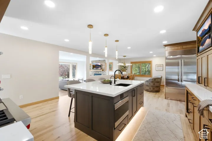 Kitchen featuring a large island with seating, dark cabinetry, and a built-in microwave