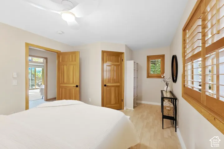 Light-toned wood-finish flooring, wood-framed doors, recessed lighting, and a ceiling fan