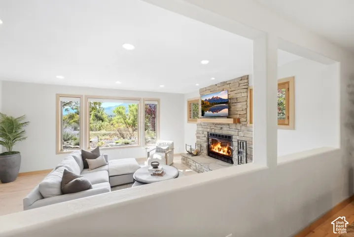 Living space with stone-clad fireplace, wood mantel, and multiple windows
