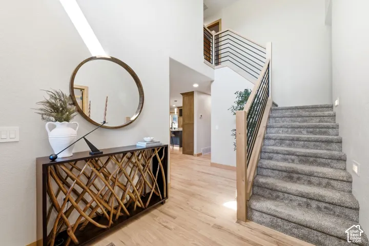 A grand entryway with ample natural light, refinished hardwood flooring, and ample space will be welcoming to any guest.
