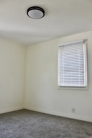 Neutral wall tones with a window featuring horizontal blinds
