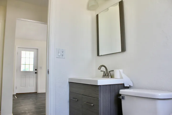 Vanity featuring a single basin, integrated countertop, and brushed nickel faucet