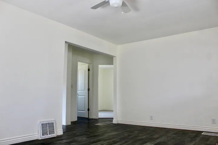 Dark wood-finish flooring with light wall paint and white trim