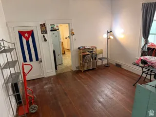 Unit 2 bedroom. Hardwood flooring throughout, white painted walls, and a window with natural light