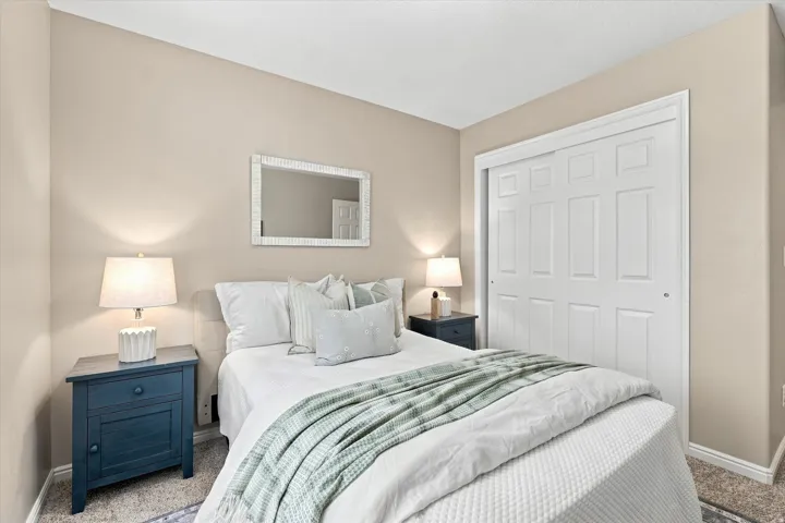 Serene bedroom retreat featuring neutral walls, recessed lighting, and a framed mirror above the bed