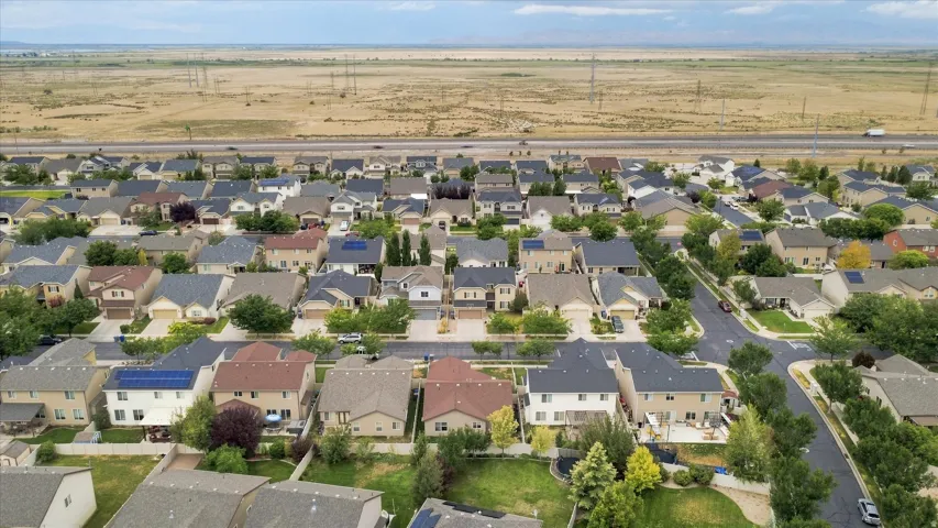 Aerial view showcasing a well-established residential neighborhood with tree-lined streets, diverse architectural styles, and single-family homes featuring varied rooflines and exterior finishes