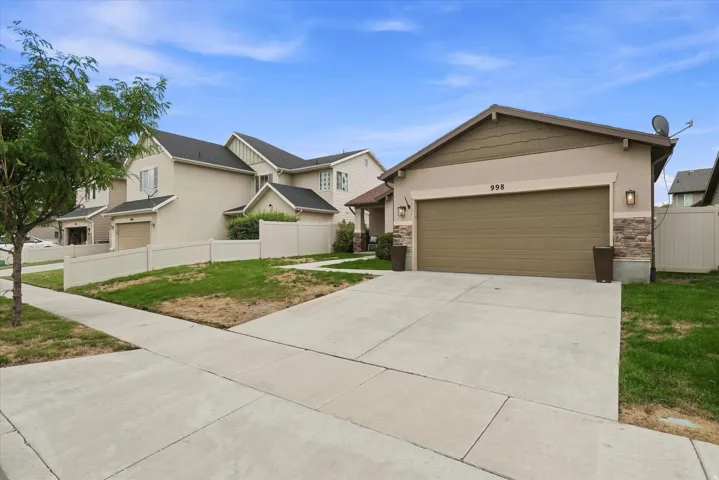 Spacious driveway with concrete apron and three-car garage featuring a neutral-finish overhead door