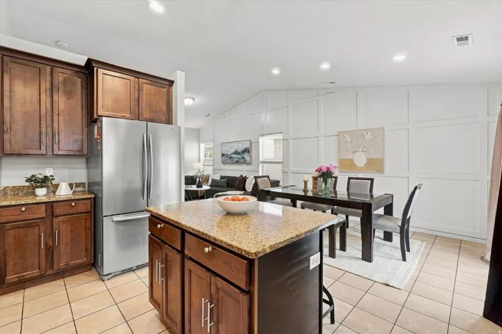 Kitchen featuring wood cabinetry, granite countertops, and tile flooring