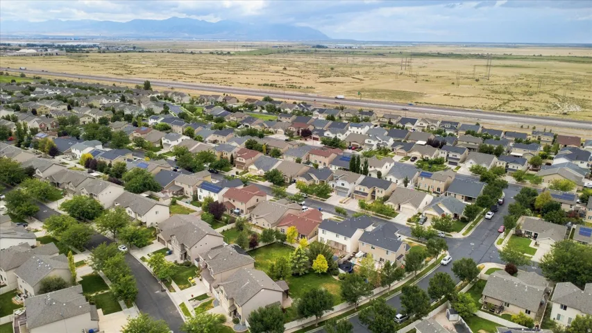Established residential community featuring single-family homes with manicured landscaping, tree-lined streets, and expansive open plains visible beyond the neighborhood perimeter