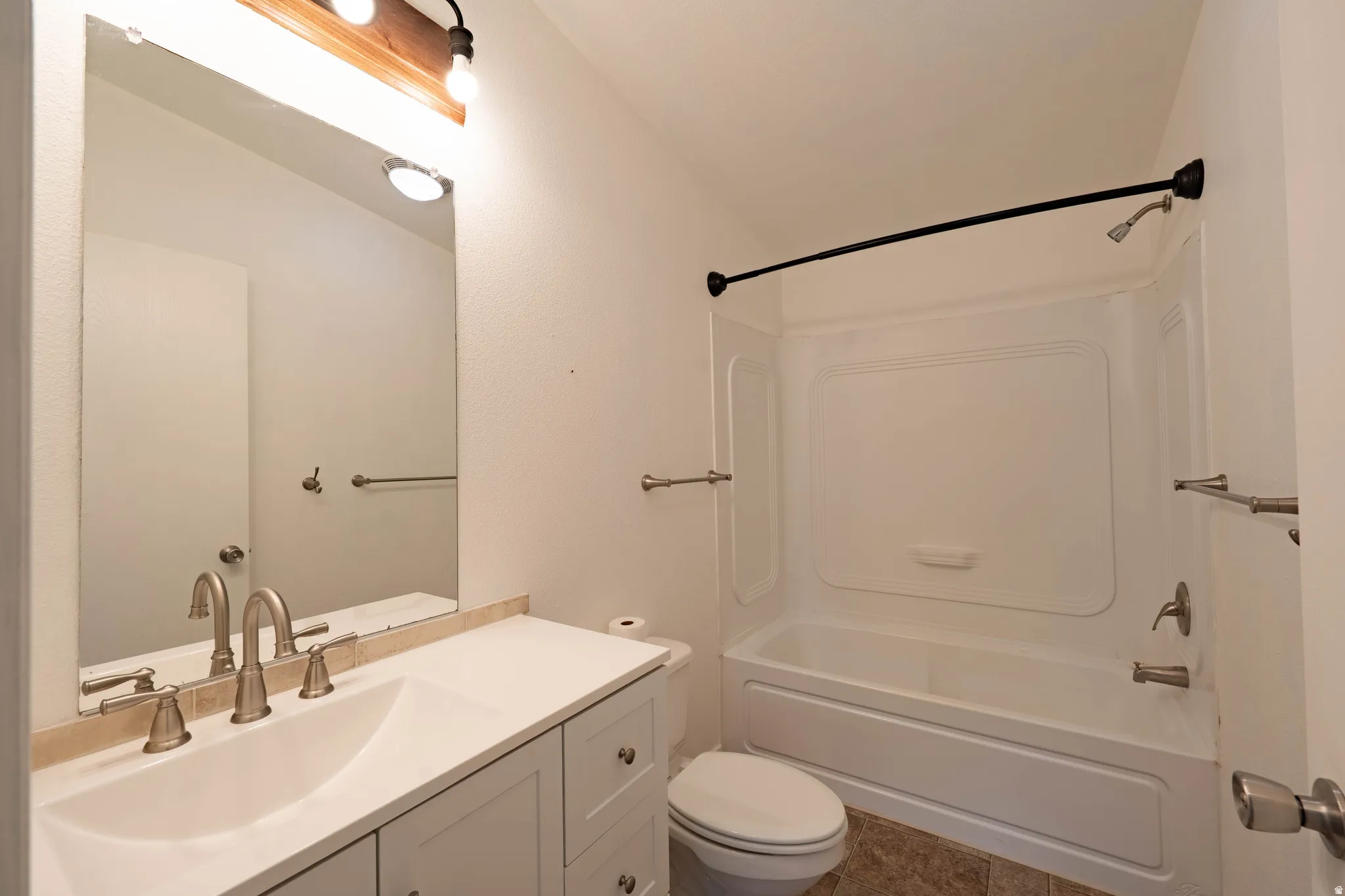 White vanity with brushed nickel hardware, integrated sink, and a light-toned countertop