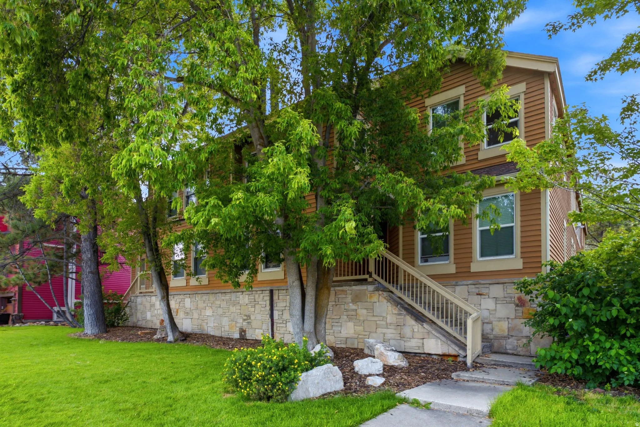 Two-story property with horizontal siding and stone veneer accents