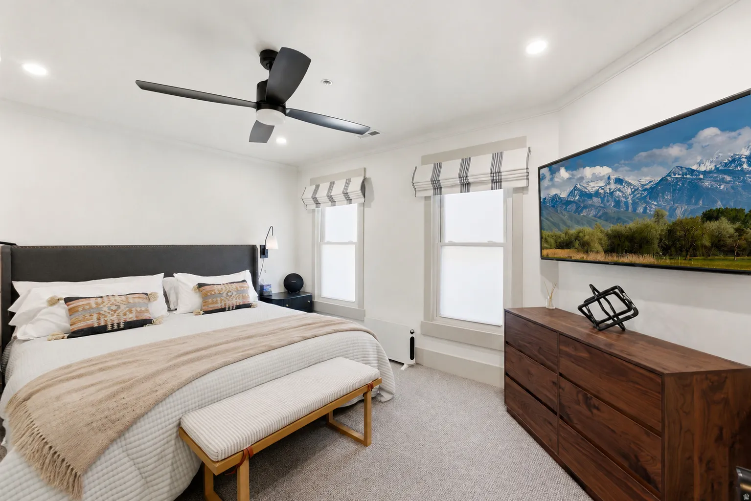Wall-mounted television above wood-finish cabinetry, recessed lighting, and a ceiling fan with integrated lighting