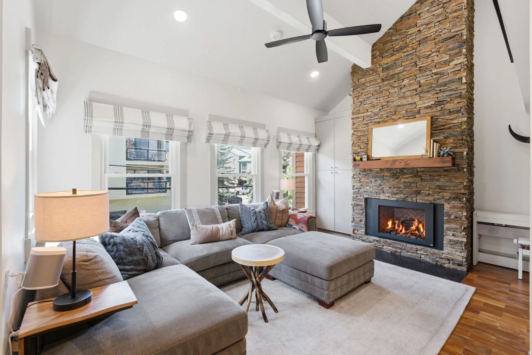 Vaulted ceilings and recessed lighting complement the stacked stone fireplace with a wood-finish mantel