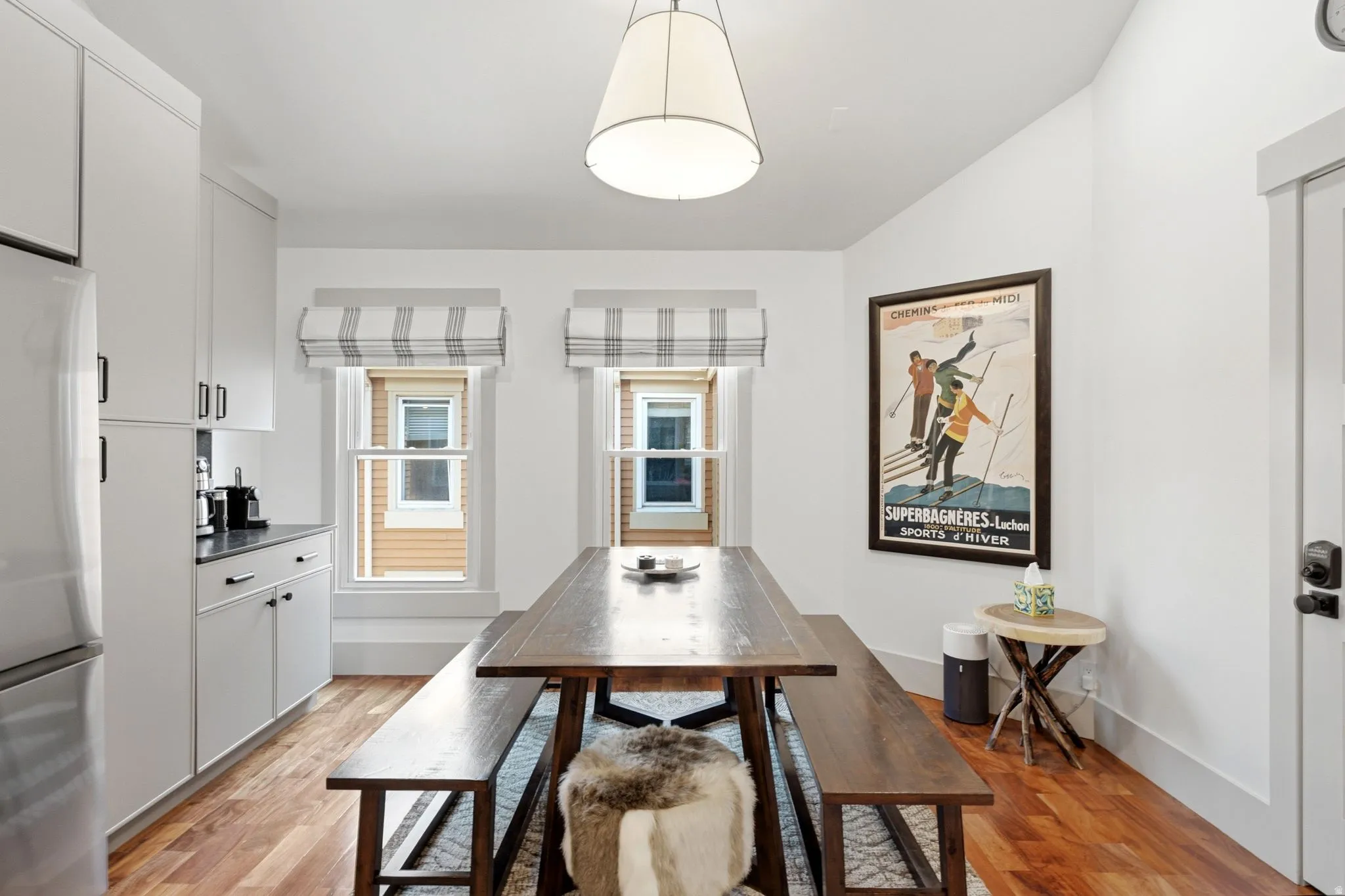 Recessed panel cabinetry with dark hardware, dark countertops, and wood-finish flooring