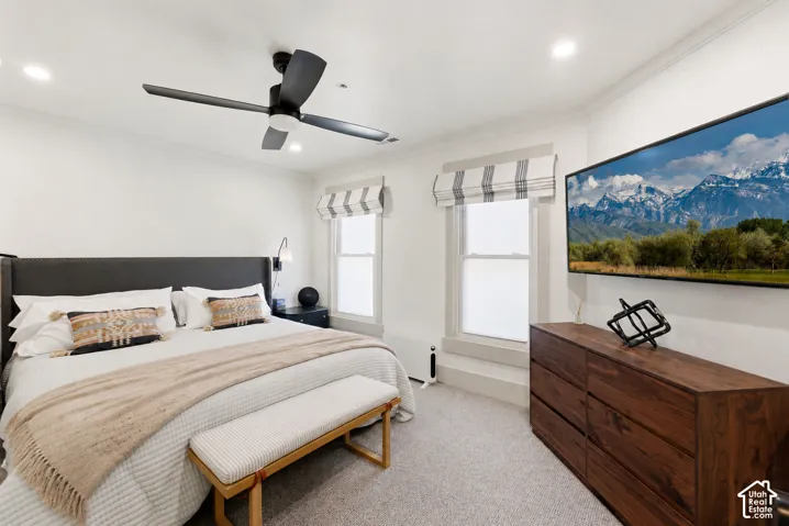 Wall-mounted television above wood-finish cabinetry, recessed lighting, and a ceiling fan with integrated lighting