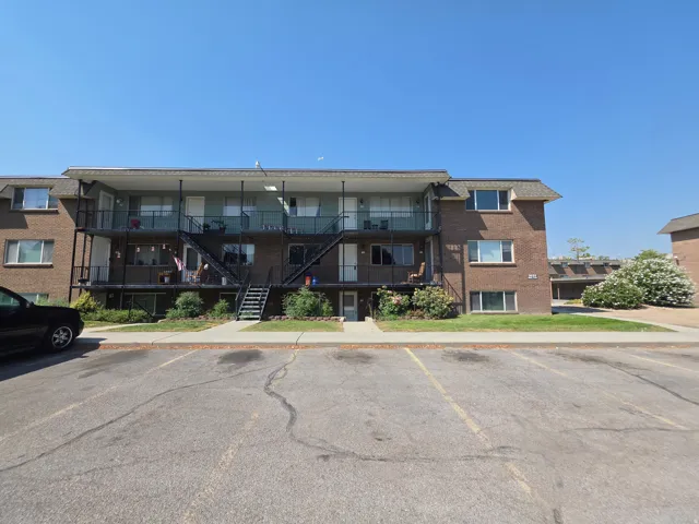 Brick exterior with multiple balconies, exterior staircases, and an on-site parking area