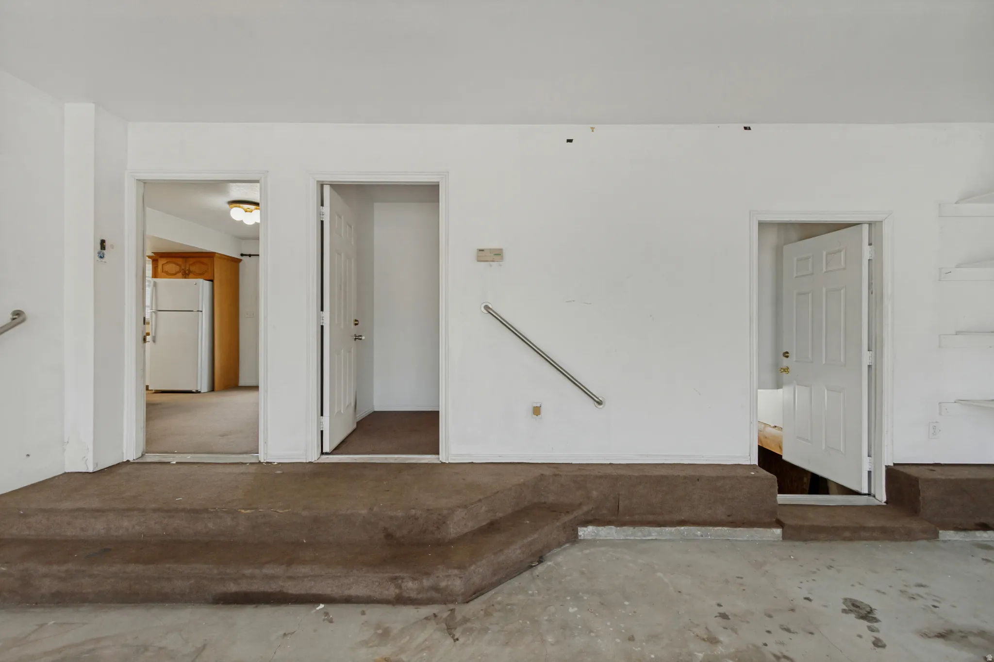 Garage showing entrance to main home, separated bedroom, and downstairs to crawl space.