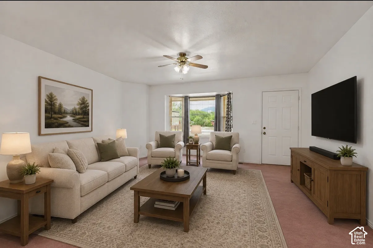Living Room. Recessed bay window, ceiling fan with integrated lighting, paneled entry door, wall-mounted television, and wood media console