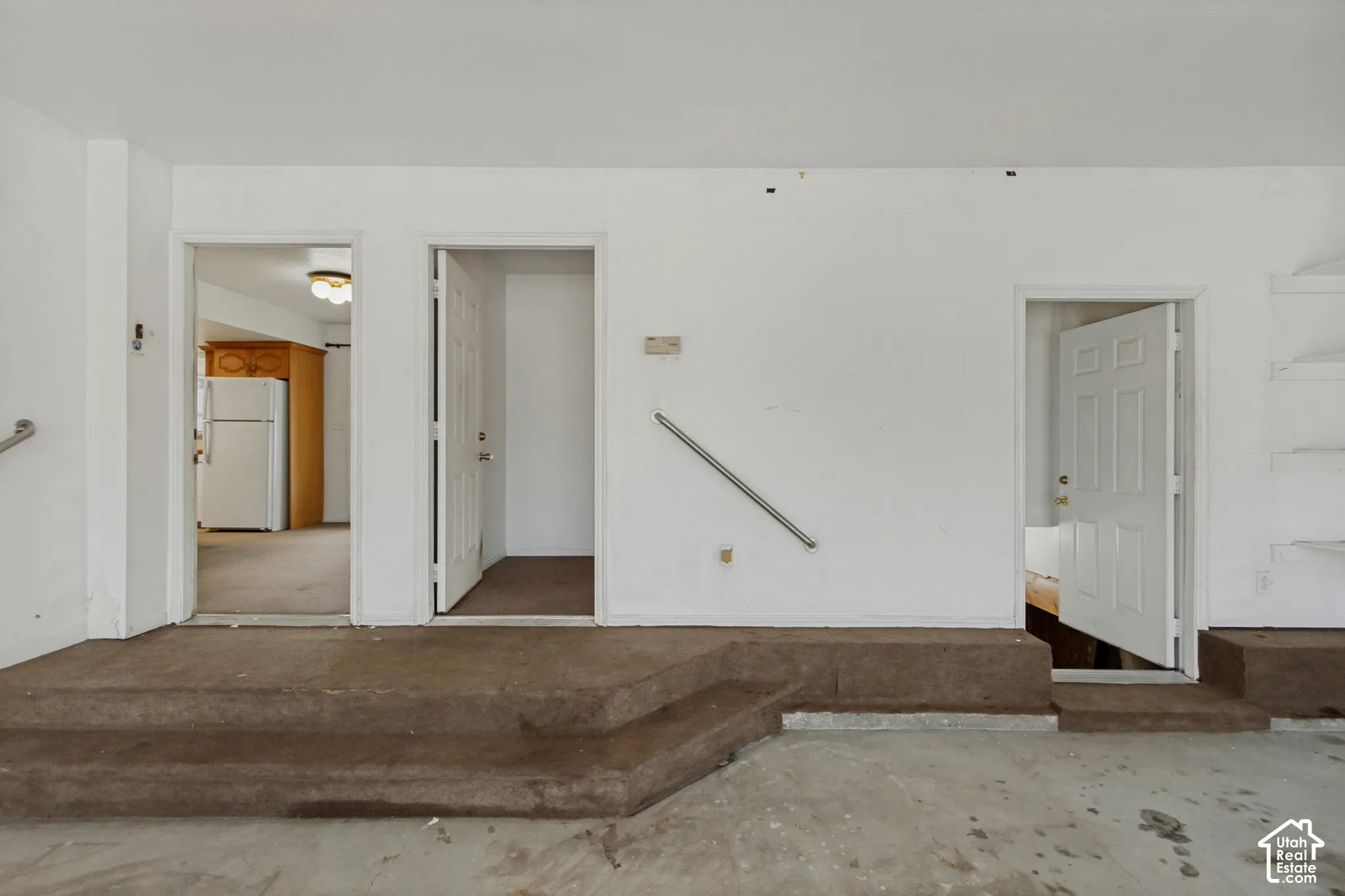 Garage showing entrance to main home, separated bedroom, and downstairs to crawl space.
