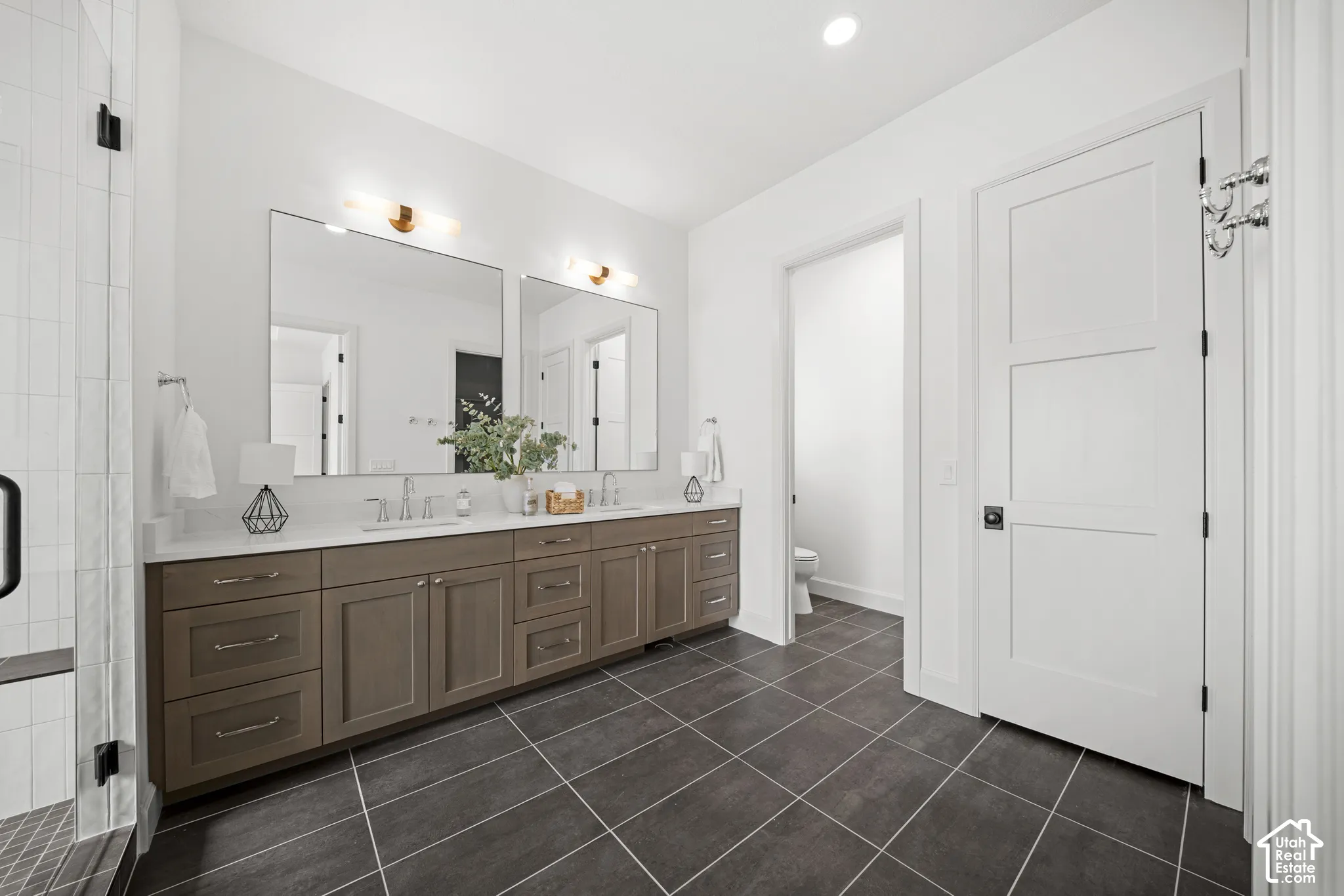 Dual vanity with wood-finish cabinetry and white countertops