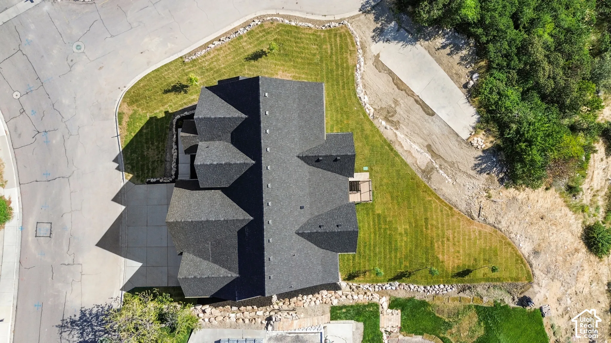 Expansive lot with a multi-gabled roofline and an asphalt shingle roof