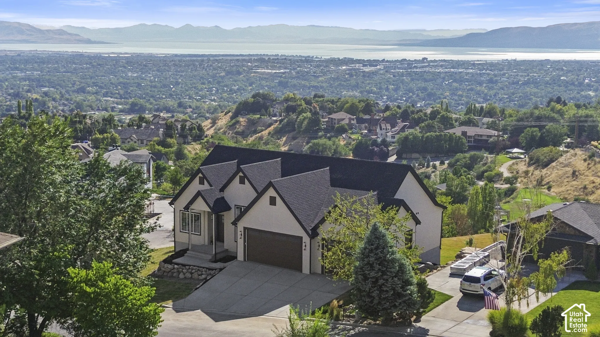 Modern-style home with a multi-gabled roof, attached garage, and paved driveway