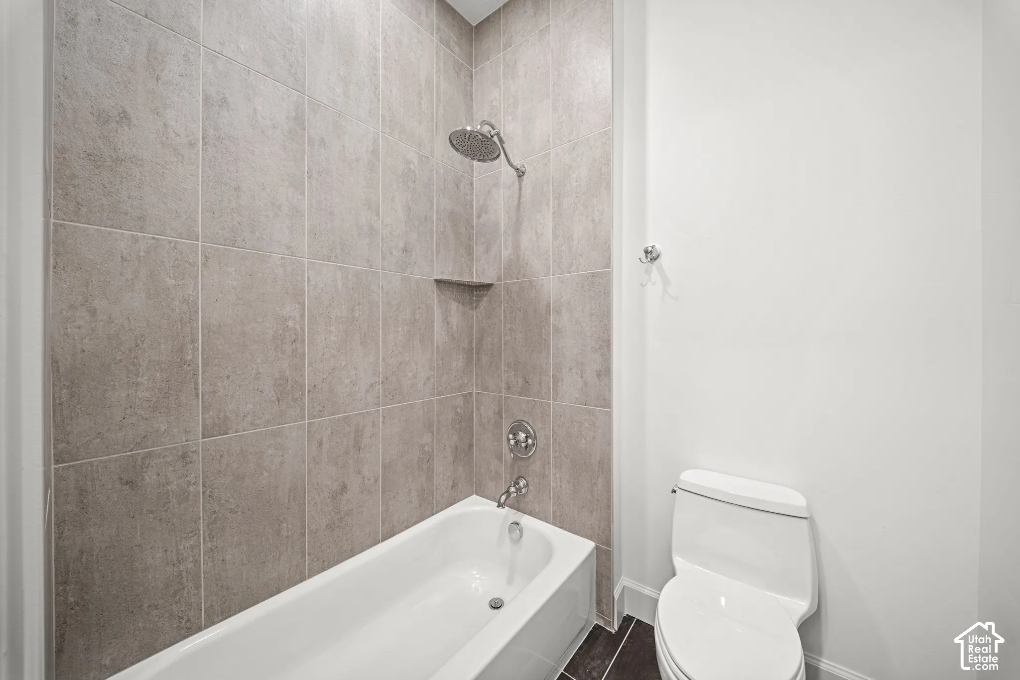 Integrated shower and tub combination featuring a rainfall showerhead, neutral-toned tile surround, and built-in shower niche