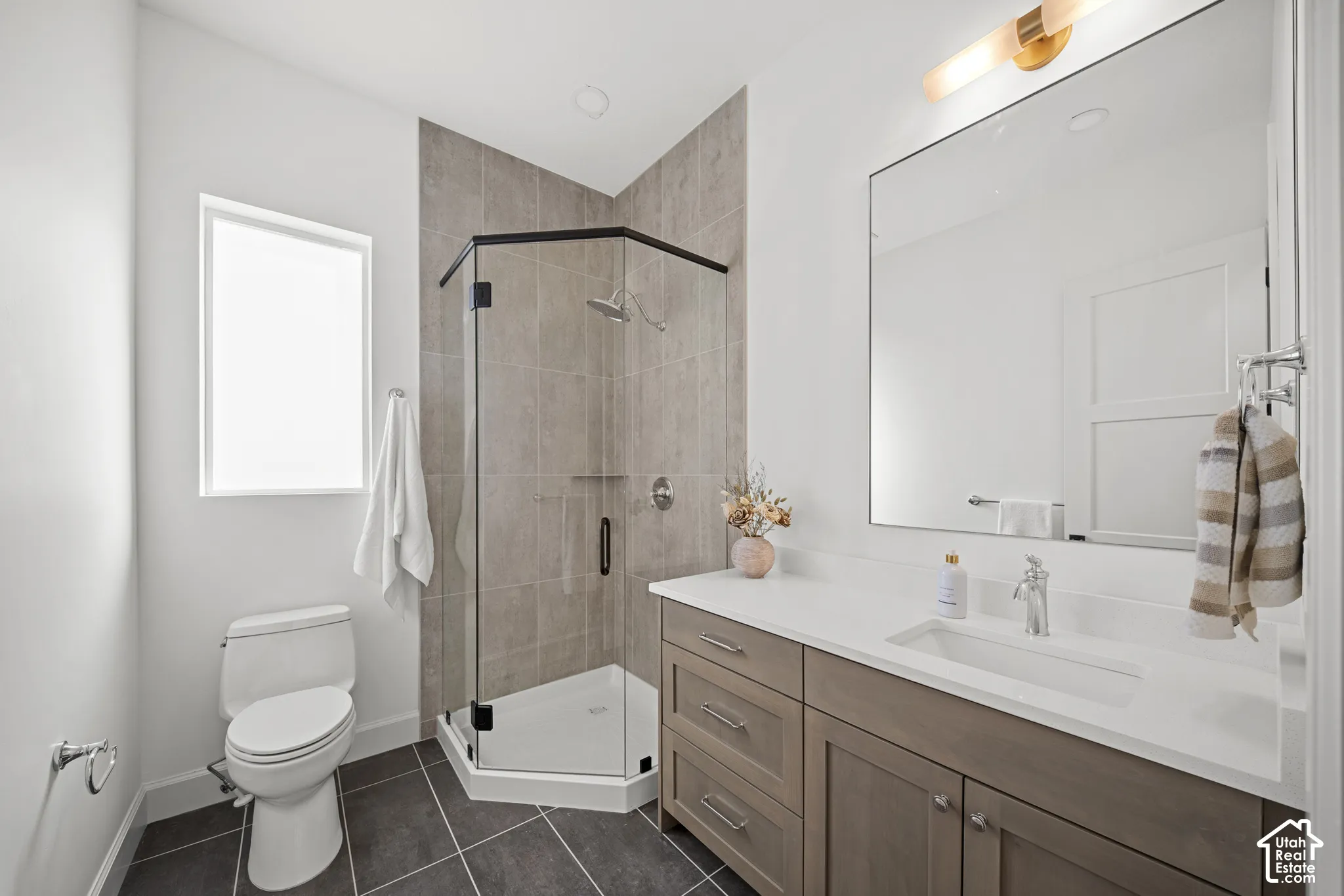 Integrated shower with dark bronze framing and neutral tile surround