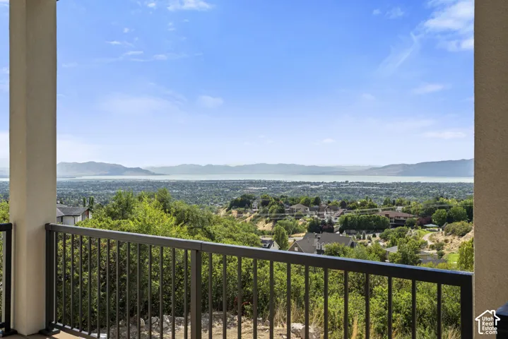 Balcony featuring a metal railing with a wide landscape and water backdrop