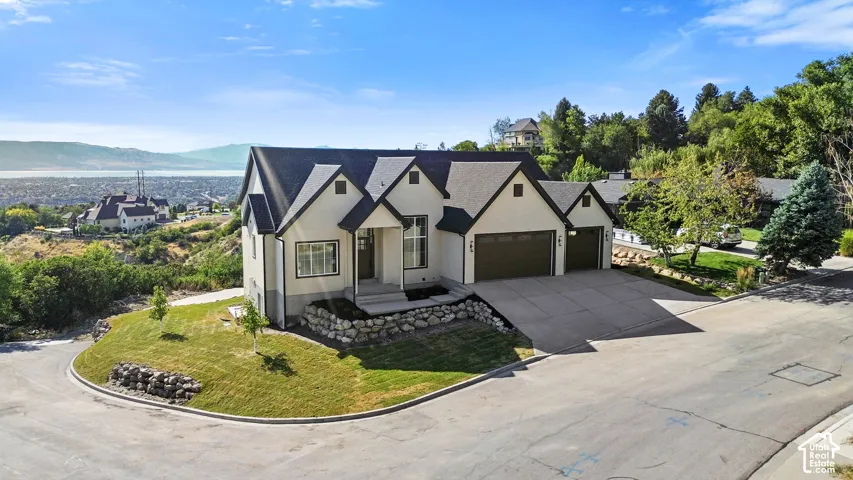 Contemporary home with a multi-gabled roofline, light-colored stucco exterior, and attached three-car garage