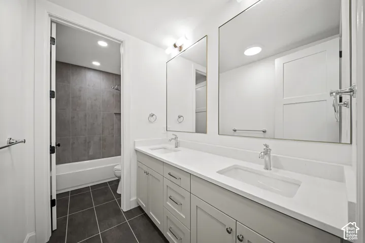 Double vanity with integrated sinks and chrome fixtures, framed mirrors, and light cabinetry