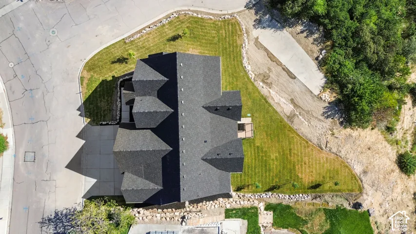 Expansive lot with a multi-gabled roofline and an asphalt shingle roof