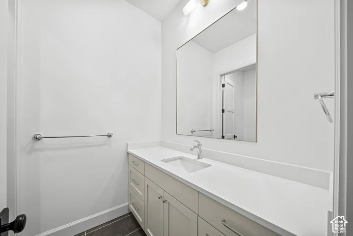 Recessed sink with chrome faucet, light-toned countertop, and recessed panel cabinetry