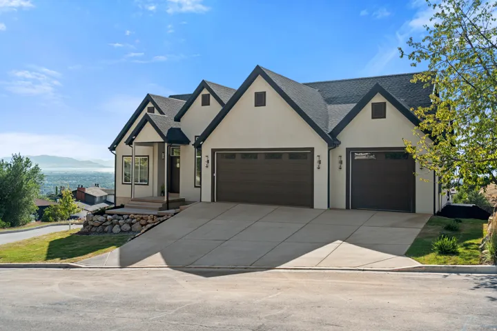 Contemporary stucco exterior with dark trim and a gabled roofline