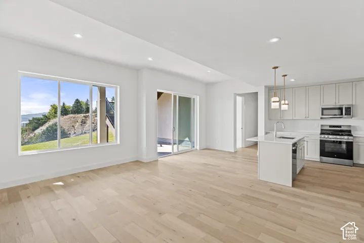 Open-concept living space featuring wood-finish flooring, recessed lighting, and a sliding glass door to an outdoor area