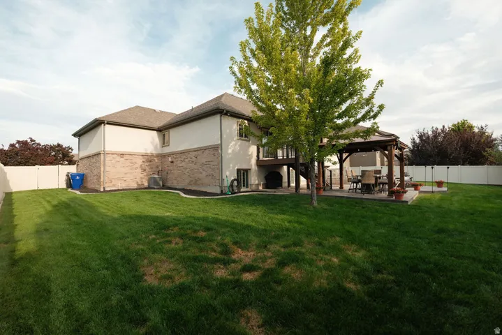 Expansive lawn space, private fencing, covered patio, and elevated deck